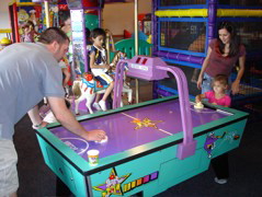 Raquel and family playing air hockey.