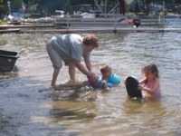 Grandma in the water with her grandkids. 